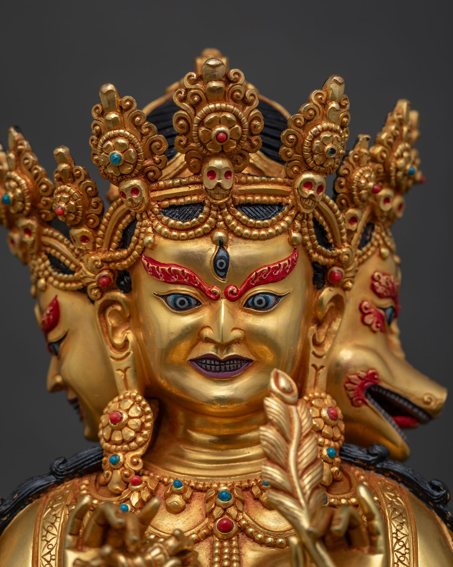 Detailed close-up of Marichi's wrathful face, skull crown, gold fire-gilded copper statue