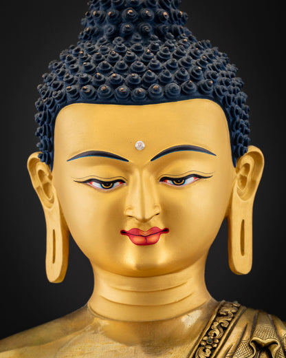 Detailed close-up of Medicine Buddha gold face with urna gemstone and blue ushnisha, Nepal copper statue