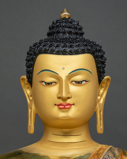 Detailed close up of Shakyamuni Buddha statue face with gold-painted features and half-closed eyes
