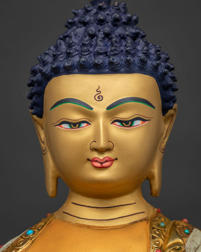 Detailed close-up of Shakyamuni Buddha's gold-painted face with tranquil downcast eyes
