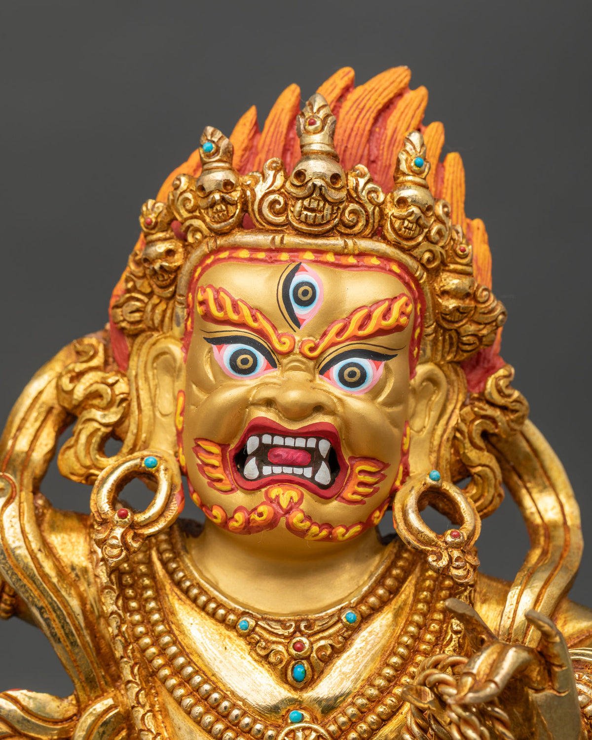 Detailed close up of Vajrapani statue face with third eye, skull crown and red painted beard
