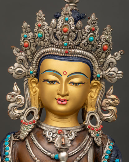 Detailed close up of Vajrasattva statue face painted in 24K gold with serene downcast eyes