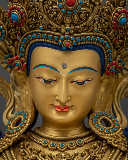 Detailed close-up of Vajrasattva statue's gold-painted serene meditative face