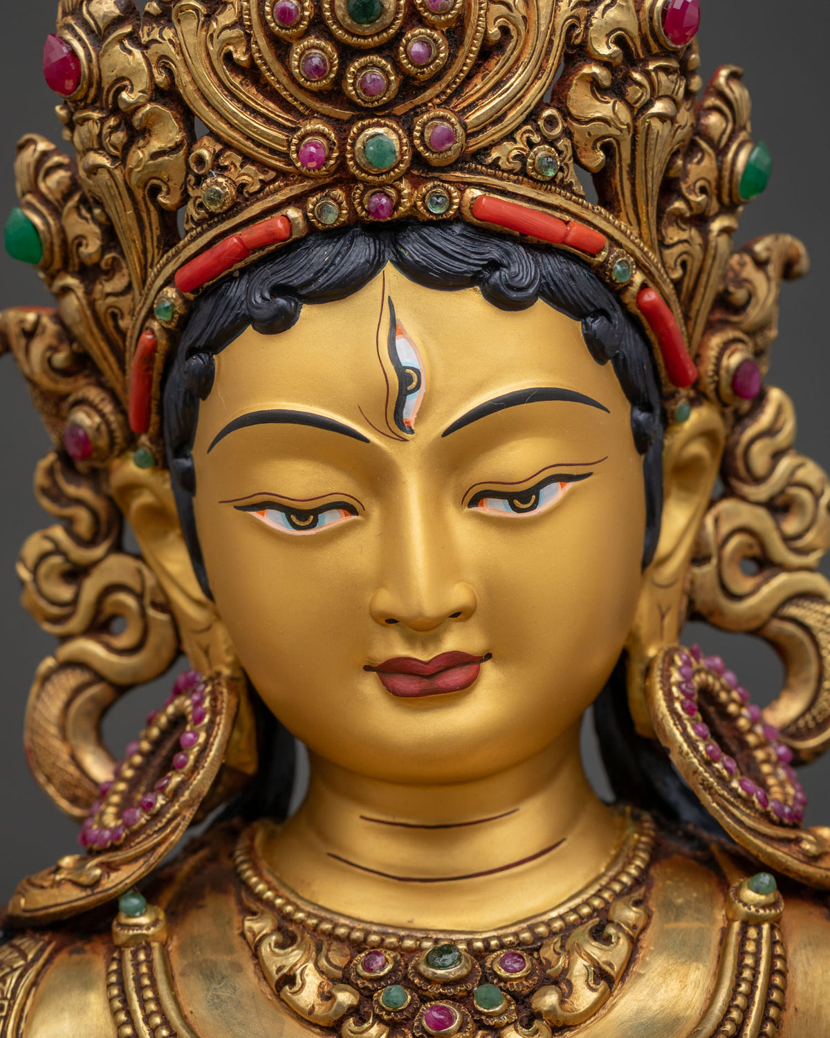 Detailed close up of White Tara Statue's gold-painted face with seven all-seeing eyes