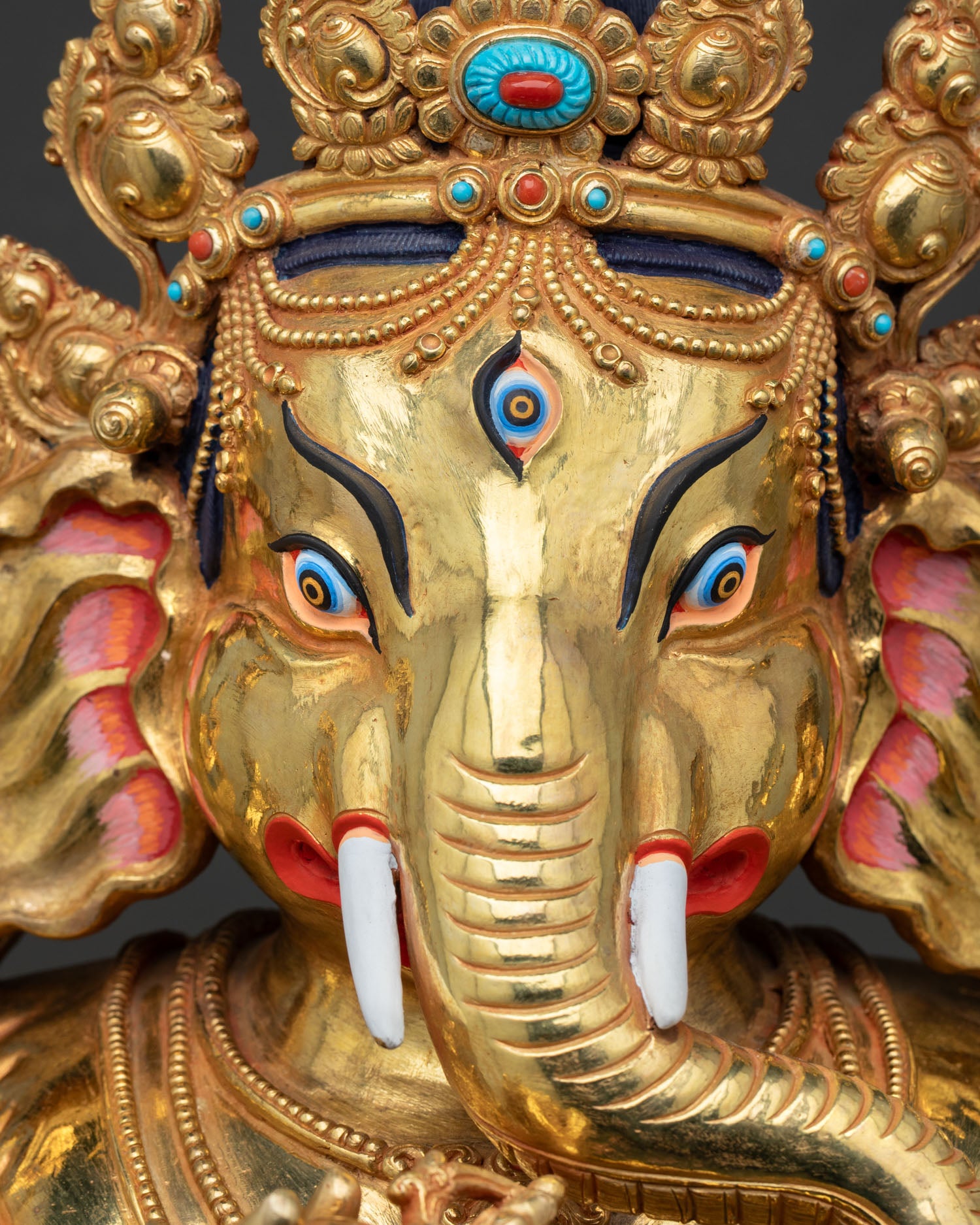 Detailed crown of Ganesh statue with turquoise coral gemstone inlay work