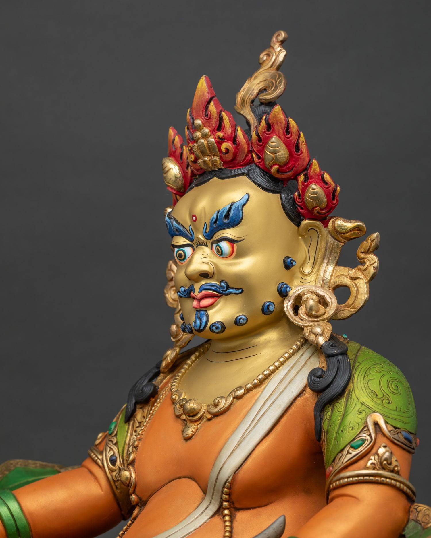 Detailed Dzambhala statue face showing serene expression ornate crownd