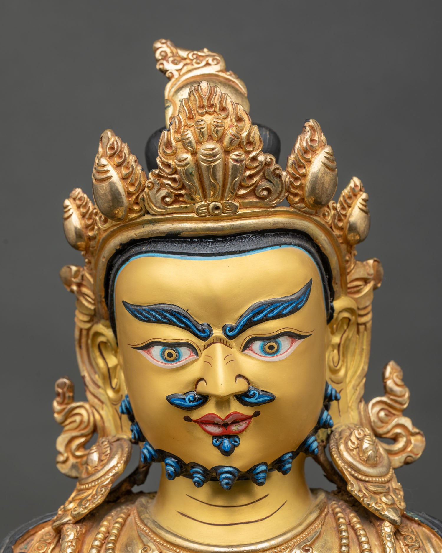 Detailed face close-up of Dzambhala Statue, gold and blue features, fierce yet compassionate
