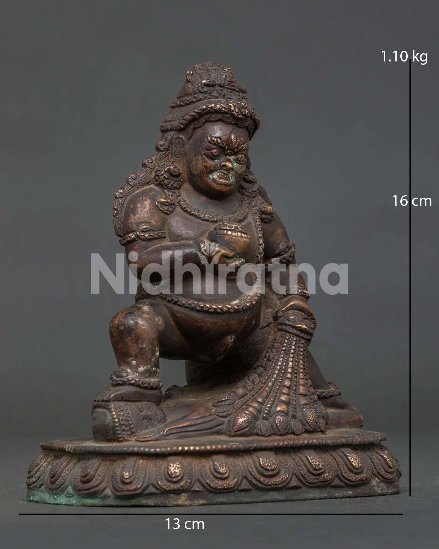 Detailed face of Black Dzambhala Statue with fierce expression and antique copper craftsmanship.