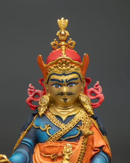 Detailed face of Guru Rinpoche statue featuring a gold-gilded crown and fine hand-painted features.