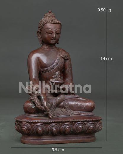 Detailed face of Medicine Buddha Statue with serene expression and hand-carved monk's robe.
