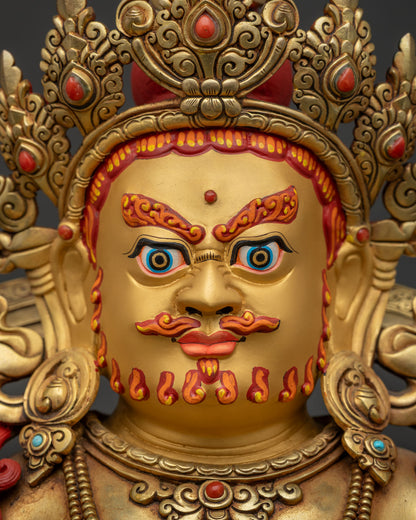 detailed face of Yellow Dzambhala statue with fierce compassionate expression and five-jeweled crown