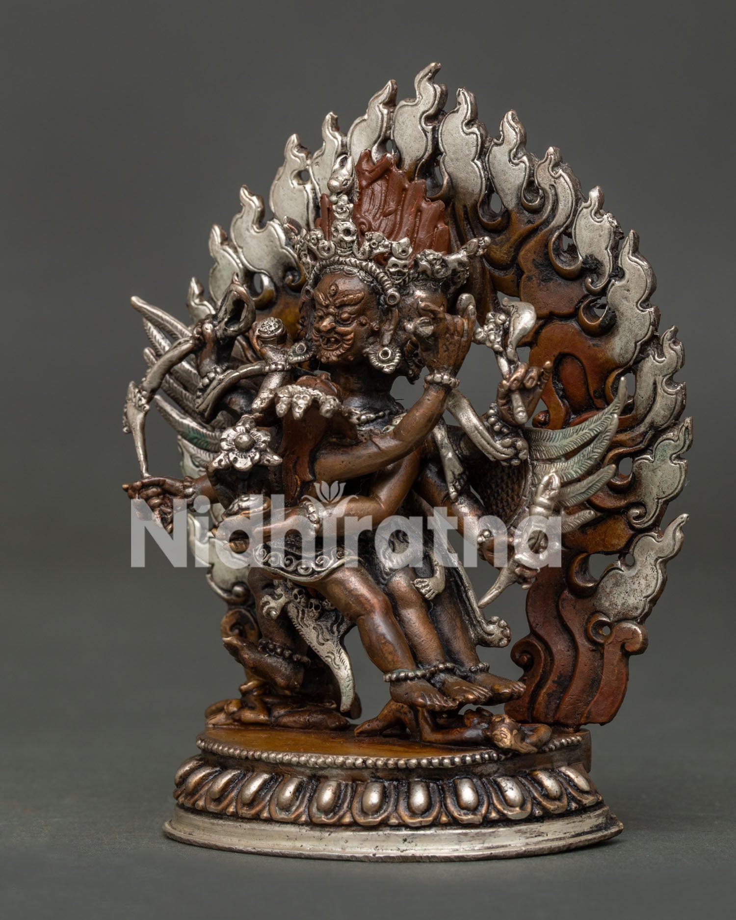Detailed Hayagriva statue with three wrathful faces and carved robes.