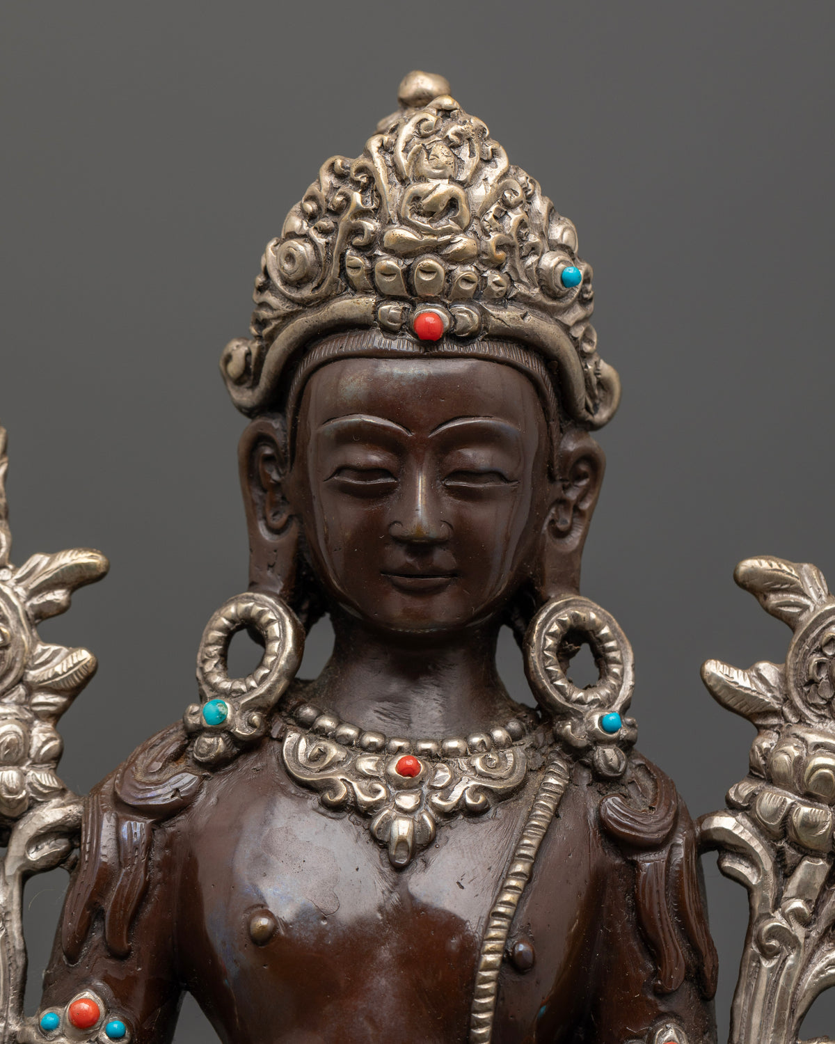 Detailed Padmapani face crown and semi precious stone ornaments.