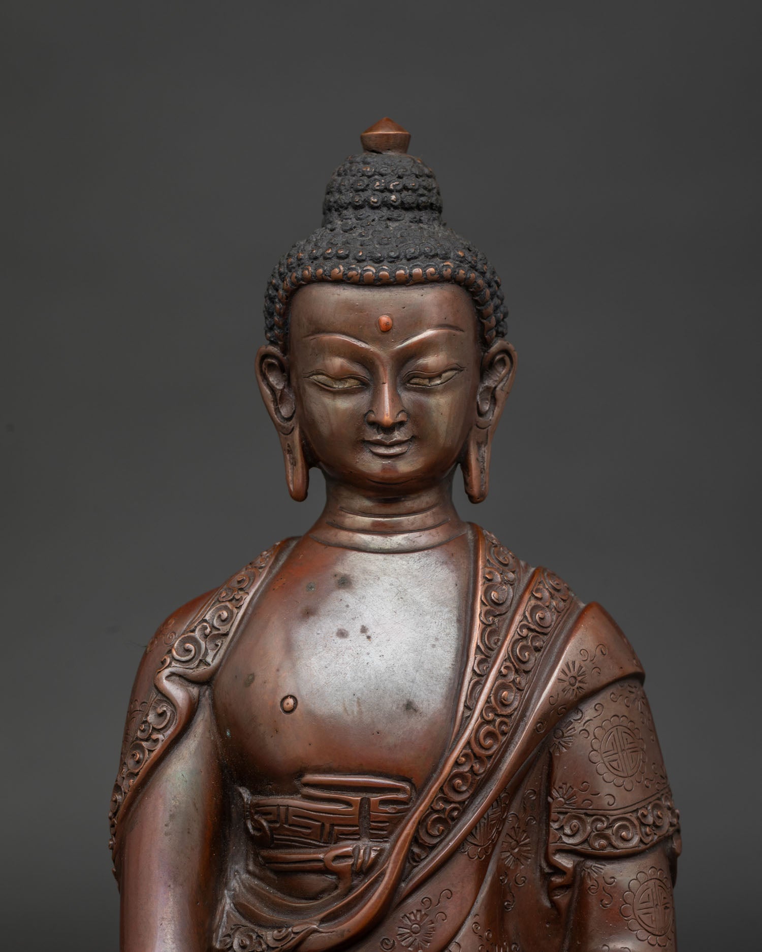 Detailed Shakyamuni Buddha face close up with handcarved floral motif monk robe.
