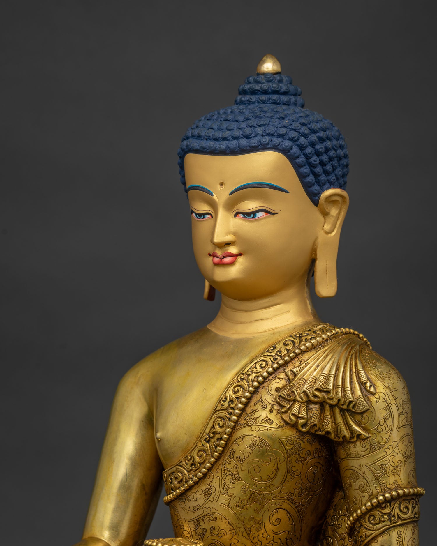 Detailed side close up of hand-carved repousse robe on copper Shakyamuni Buddha statue