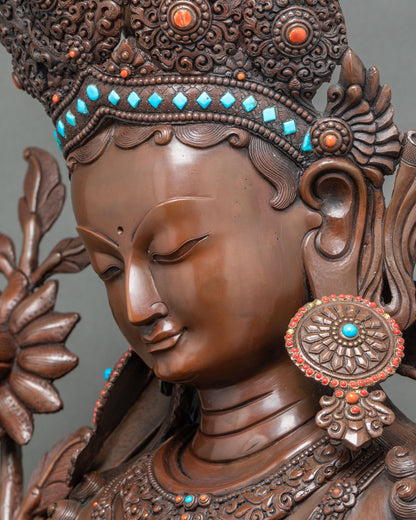Detailed side close-up showing Green Tara statue’s swirling robe and armlet details