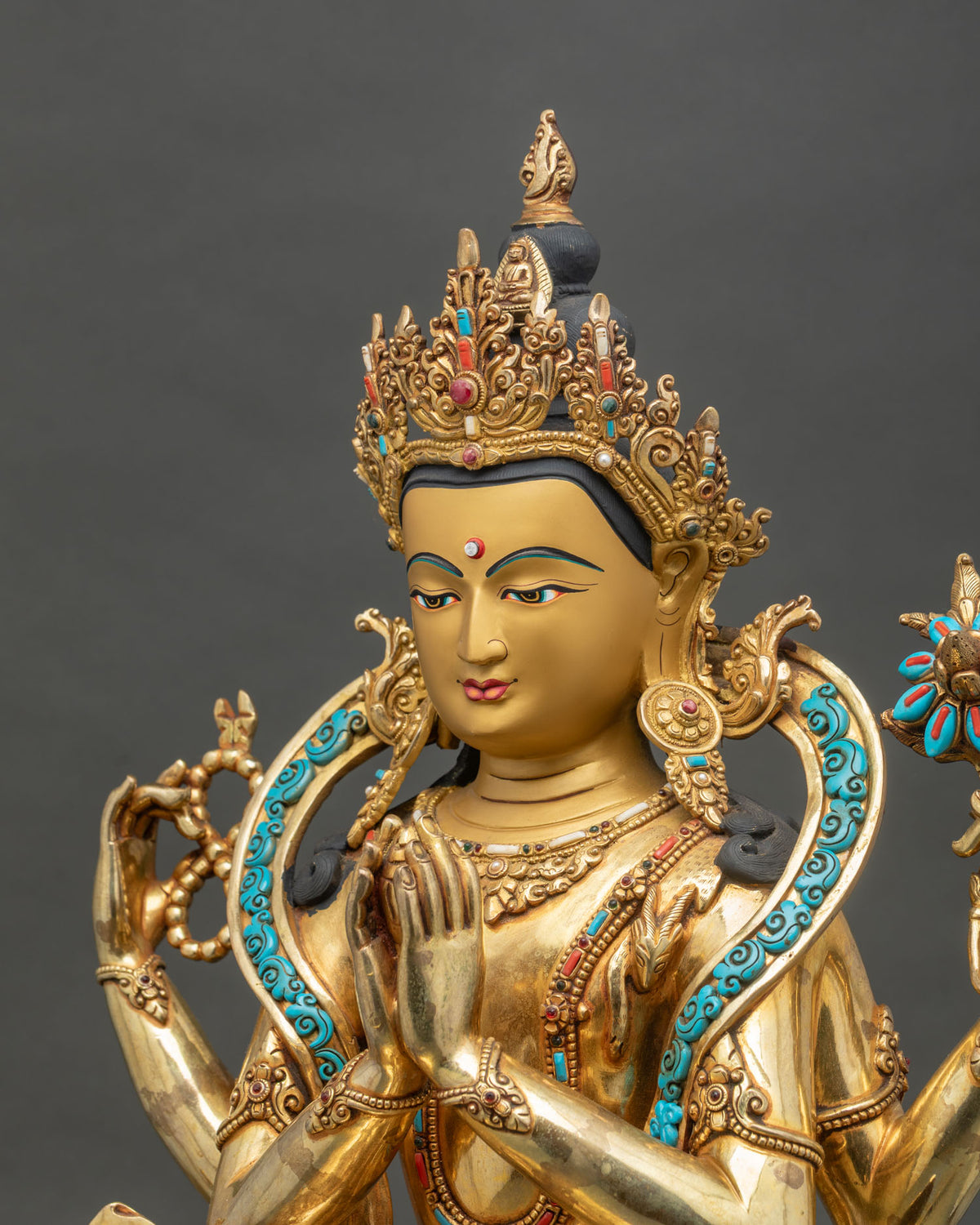 Detailed side close up of Chenrezig statue with 24K gold gilding and semi-precious inlays