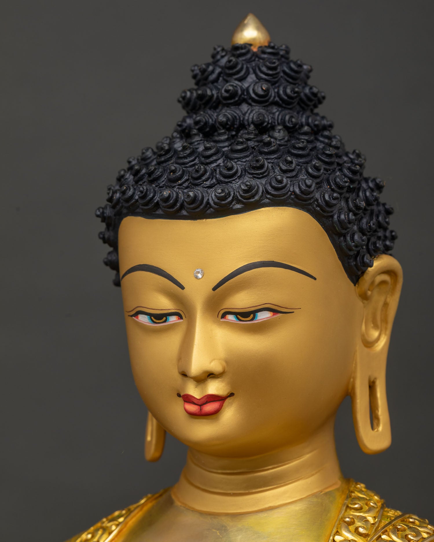 Side close-up of Shakyamuni Buddha statue's Bhutan gold face and elongated earlobes