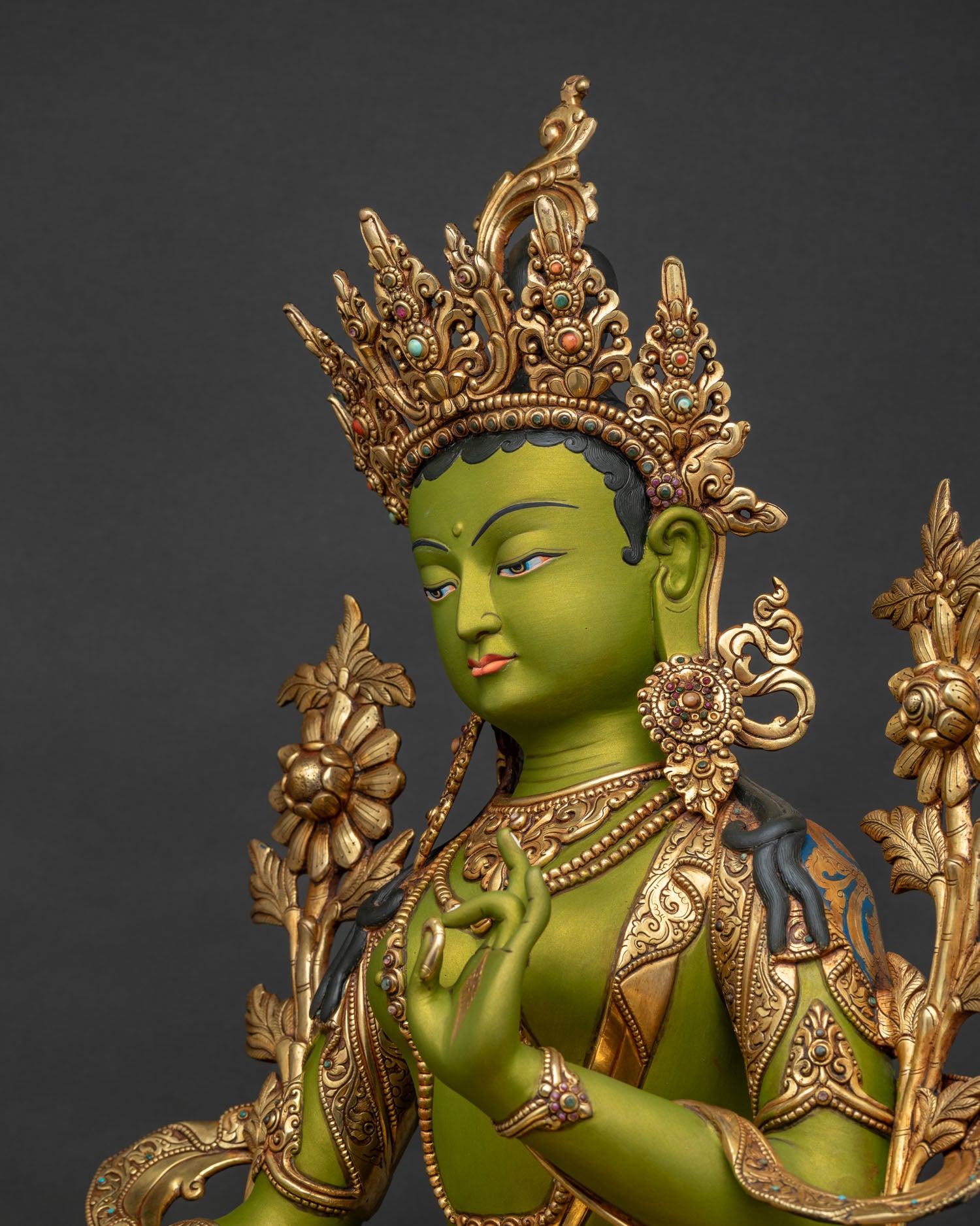 Detailed side close up of Green Tara statue showing ornate jewelry and lotus details