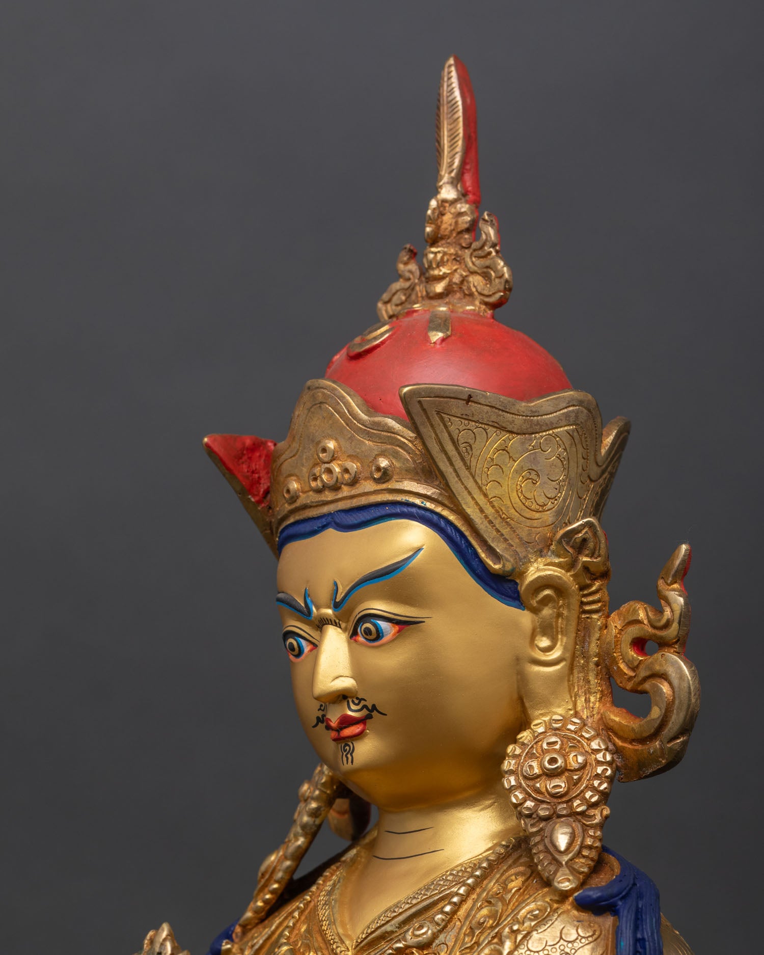 detailed side close-up of guru norlha face showing compassionate expression and crown