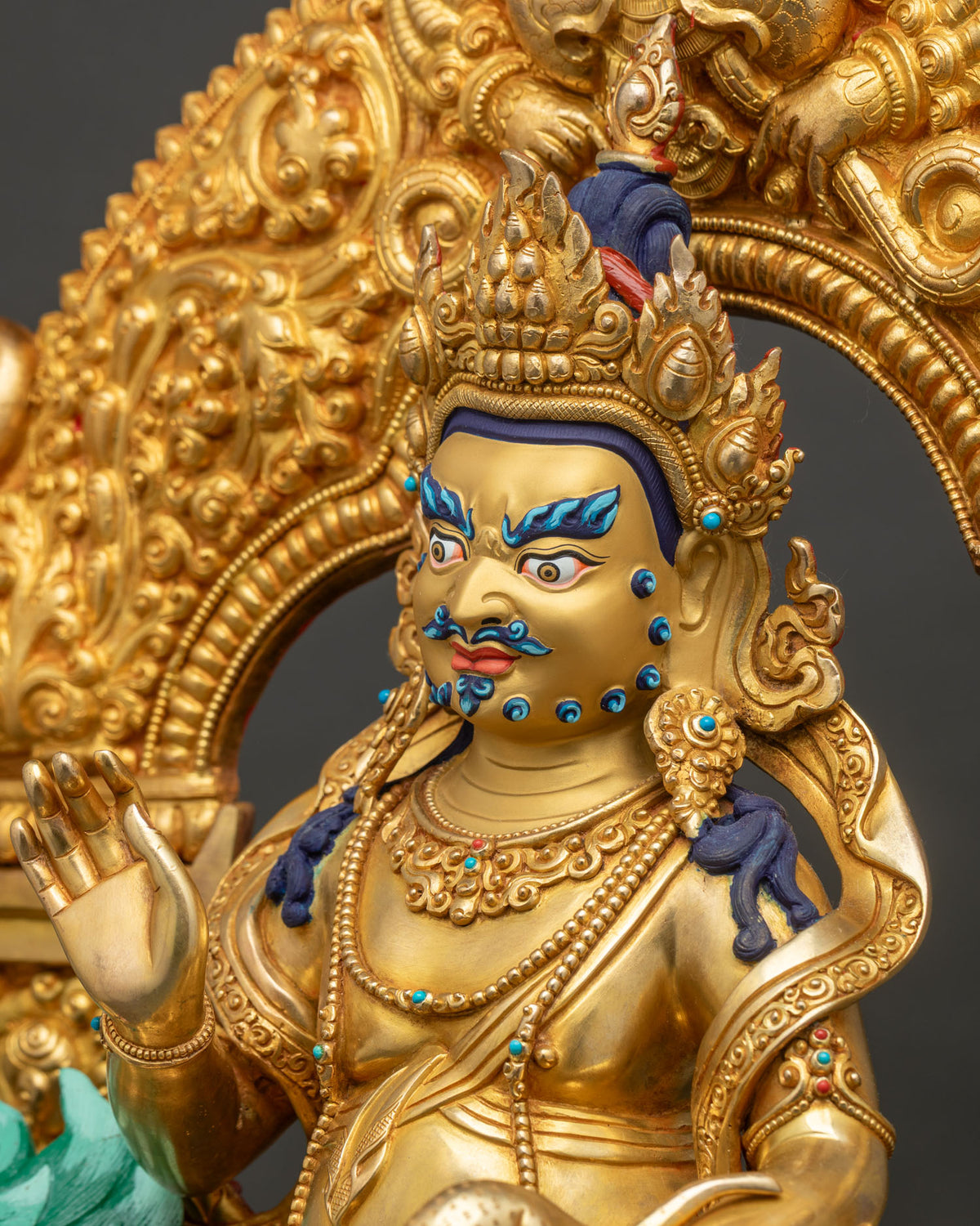 Detailed side close up of Namtoshe statue showing jeweled necklaces, flame crown and gilded halo
