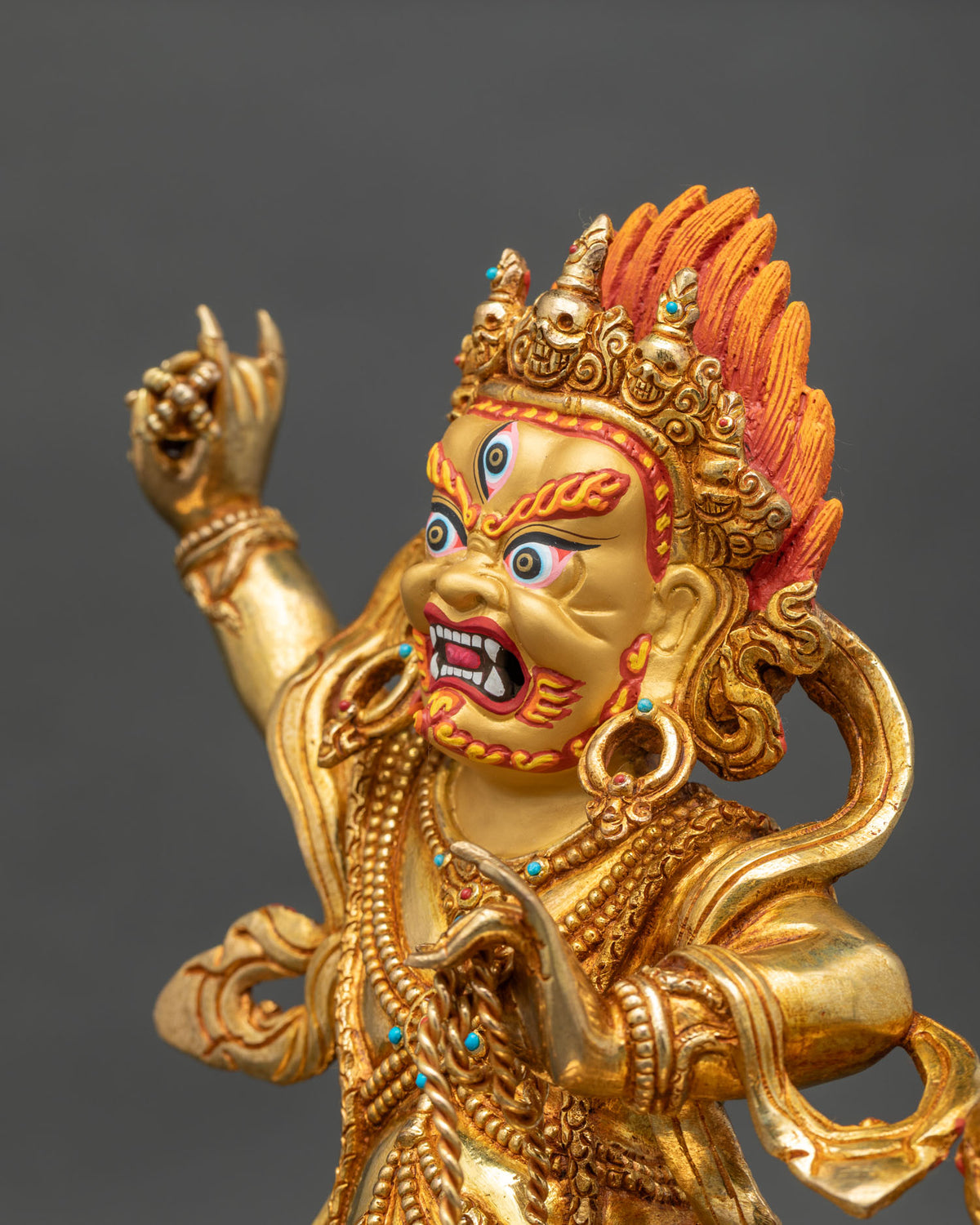 Detailed side close up of Vajrapani statue showing gold-gilded jewelry and flowing robe
