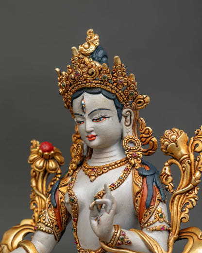 detailed side close up of white tara statue showing gold gilded ornaments and gemstones