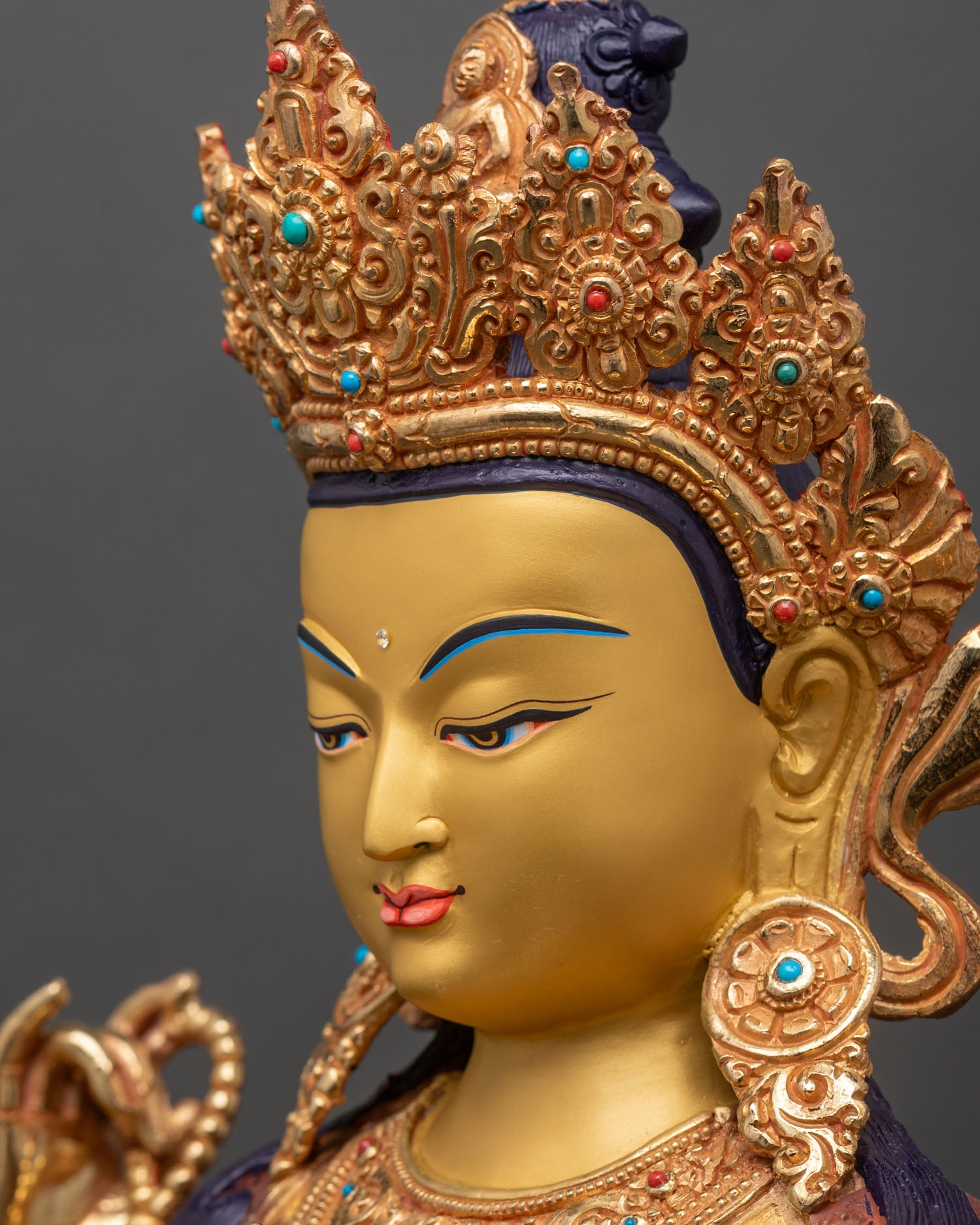 detailed side face close up of chenrezig statue, gold gilded face with calm compassionate expression