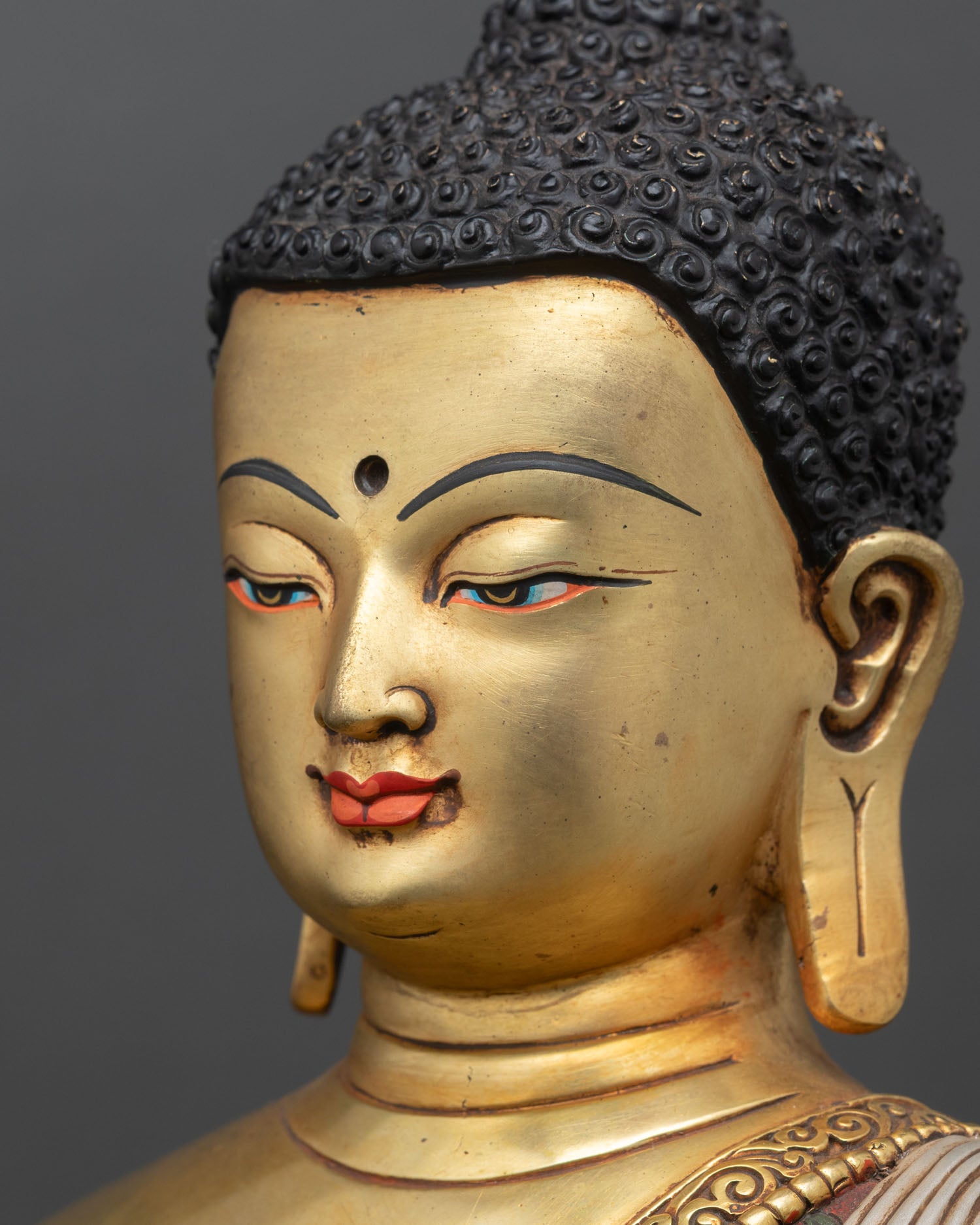 detailed side face close up of shakyamuni buddha statue with intricate gold features