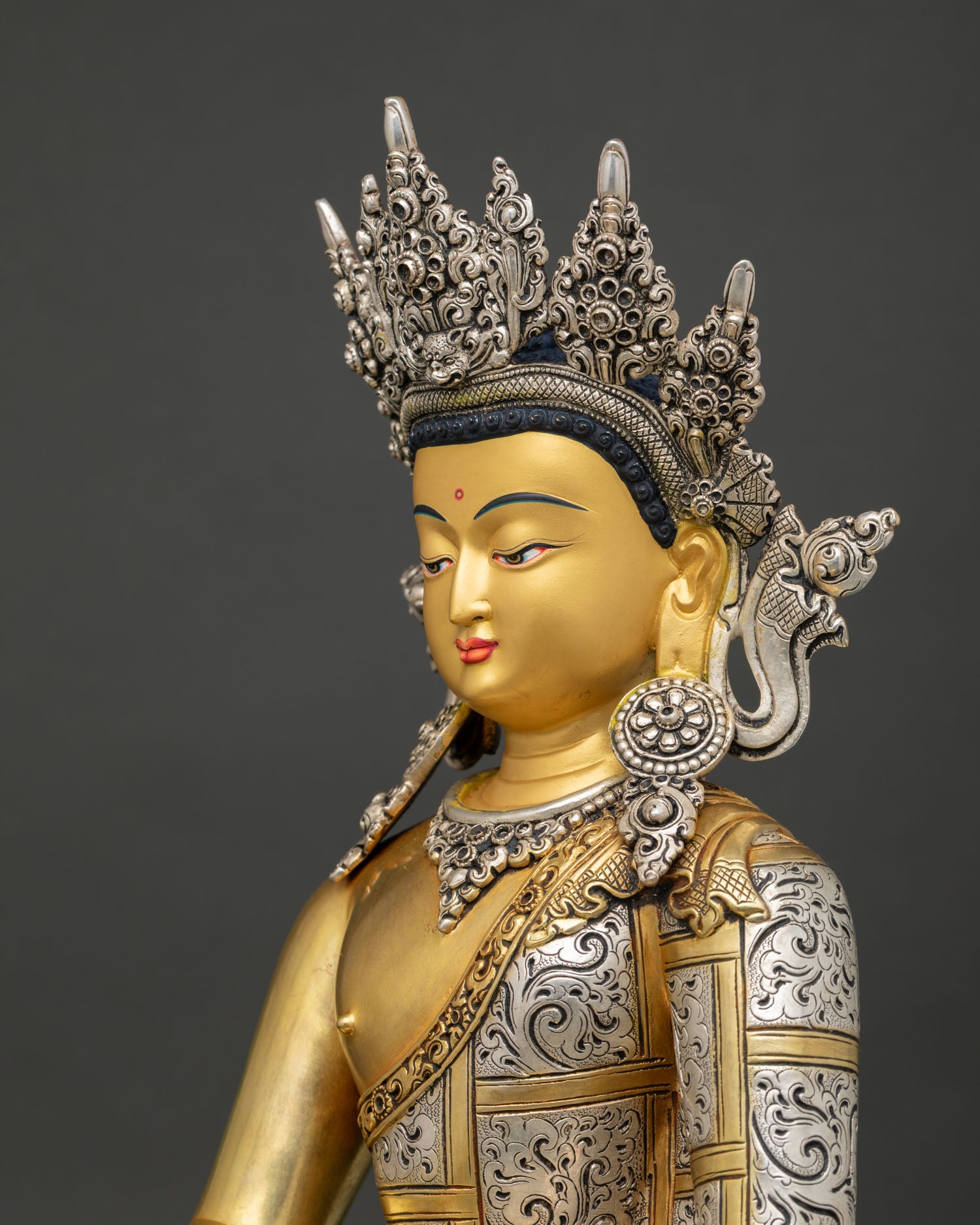 detailed side view of crowned shakyamuni buddha statue showing ornate silver embellishments