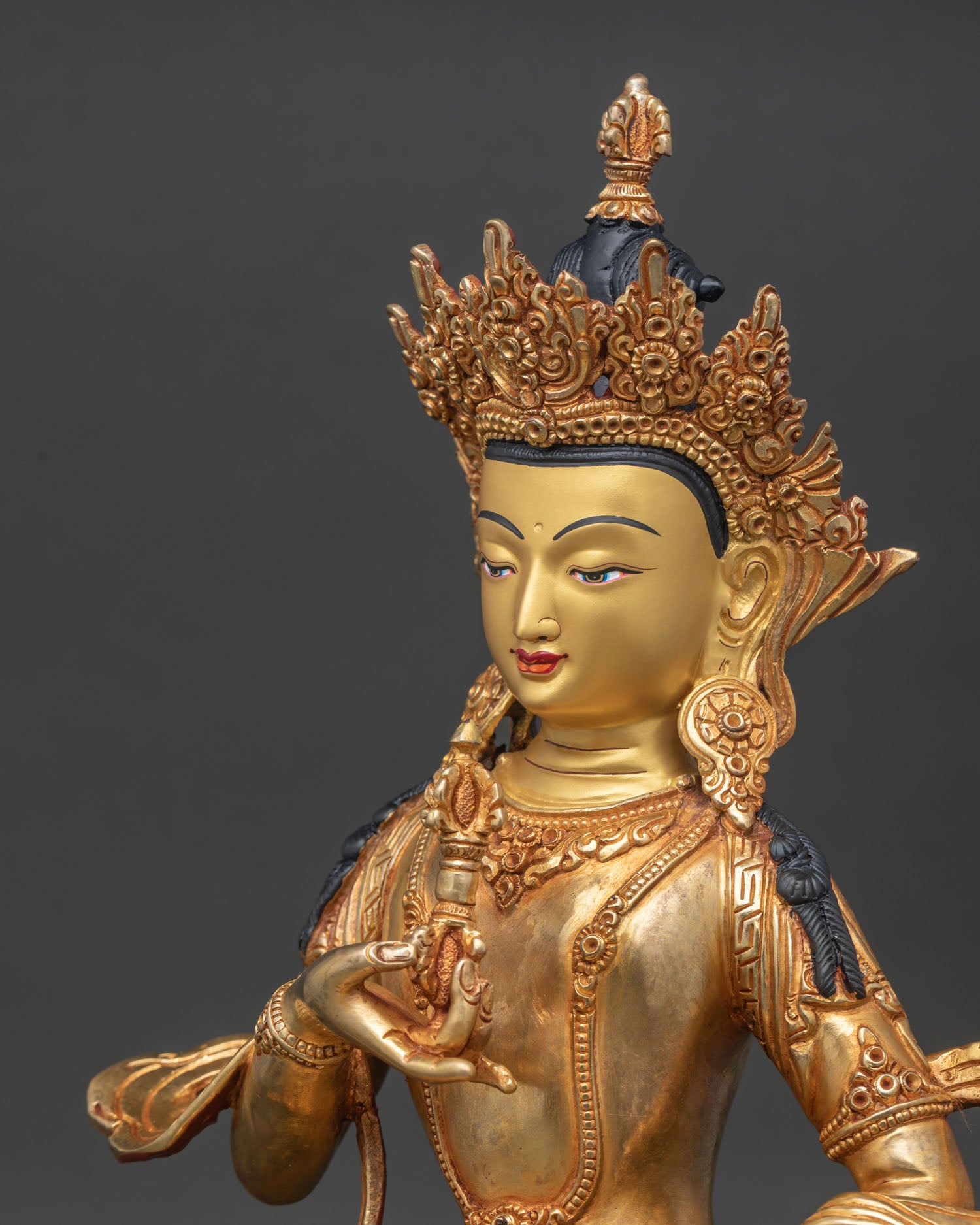 Side face close-up of Vajrasattva Statue with gold-painted face and intricate adornments