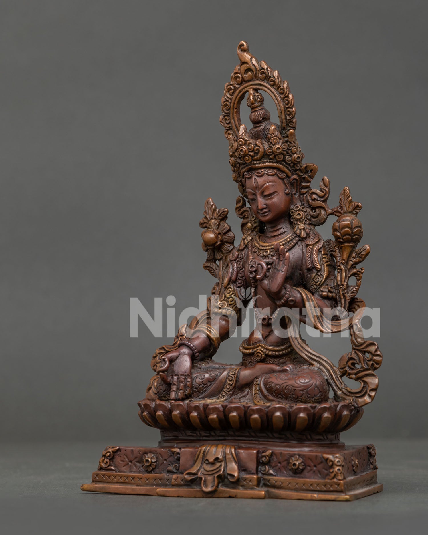 Detailed White Tara statue with hand-carved floral robe and lotus flowers.