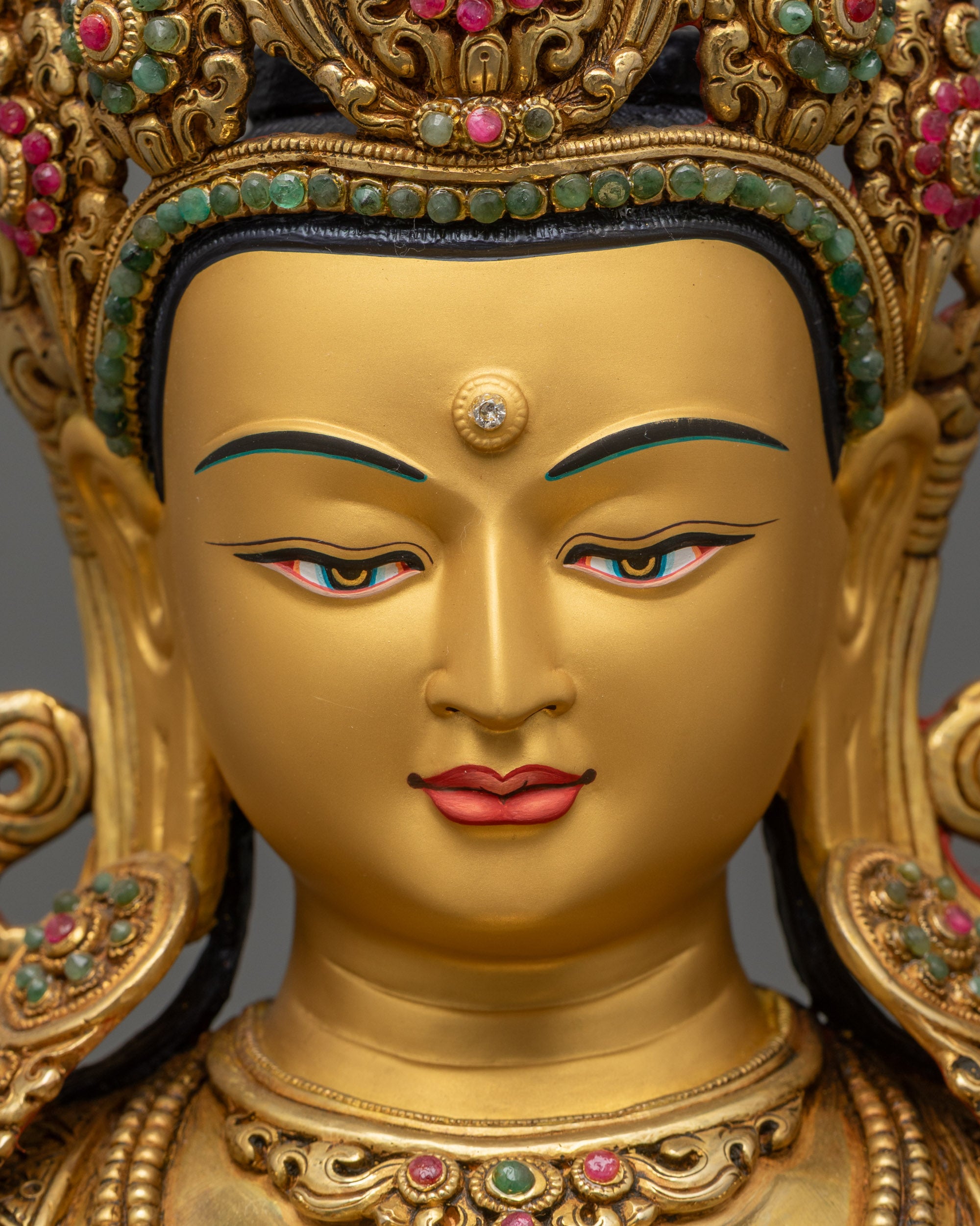 detailed close up face Manjushri Statue with radiant gold-gilded features and stones
