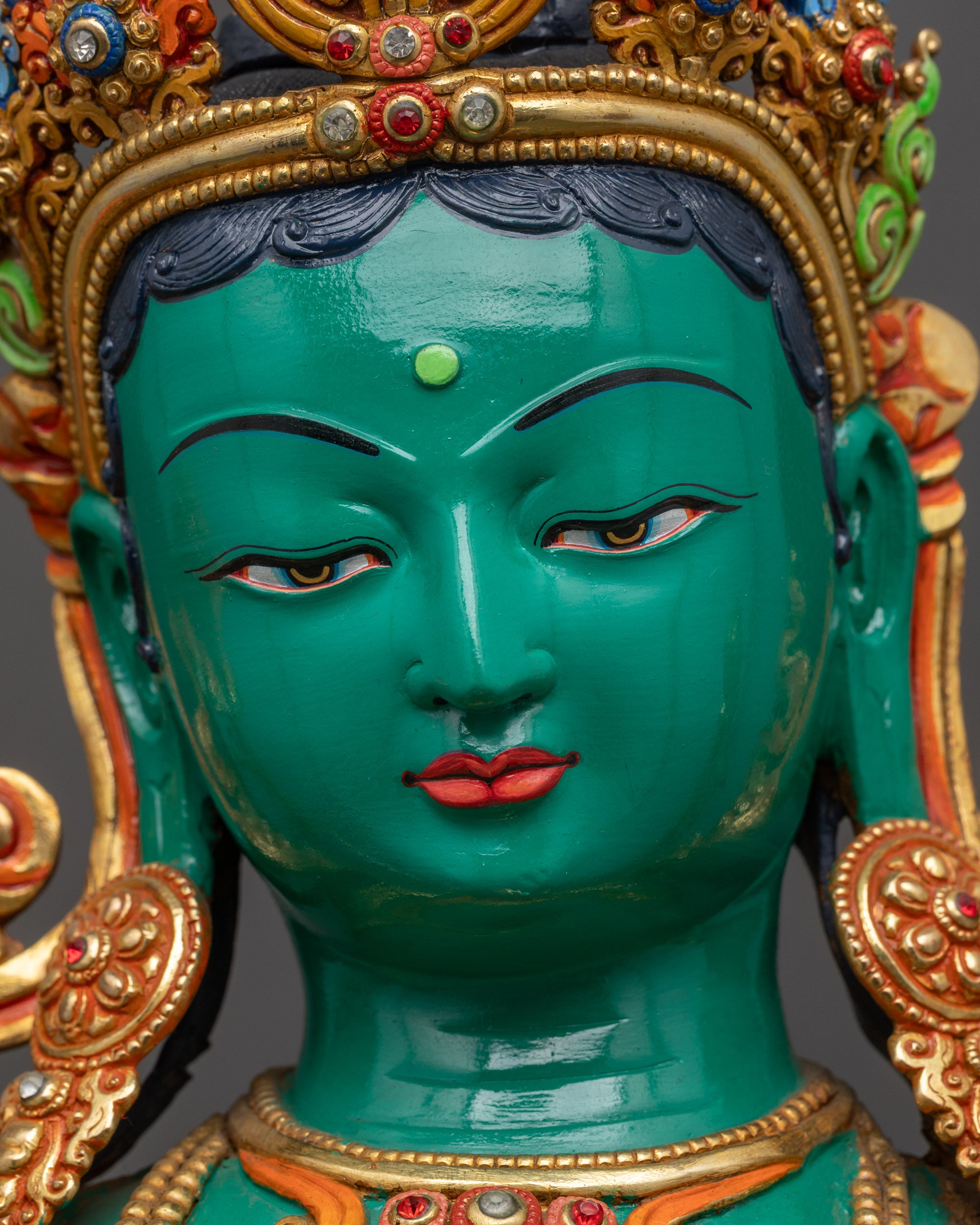 detailed close up face of Mother Green Tara copper statue with calm expression acrylic paint