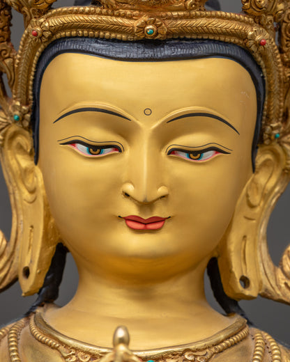 detailed close up face of Vajrasattva statue with calm gold-gilded expression
