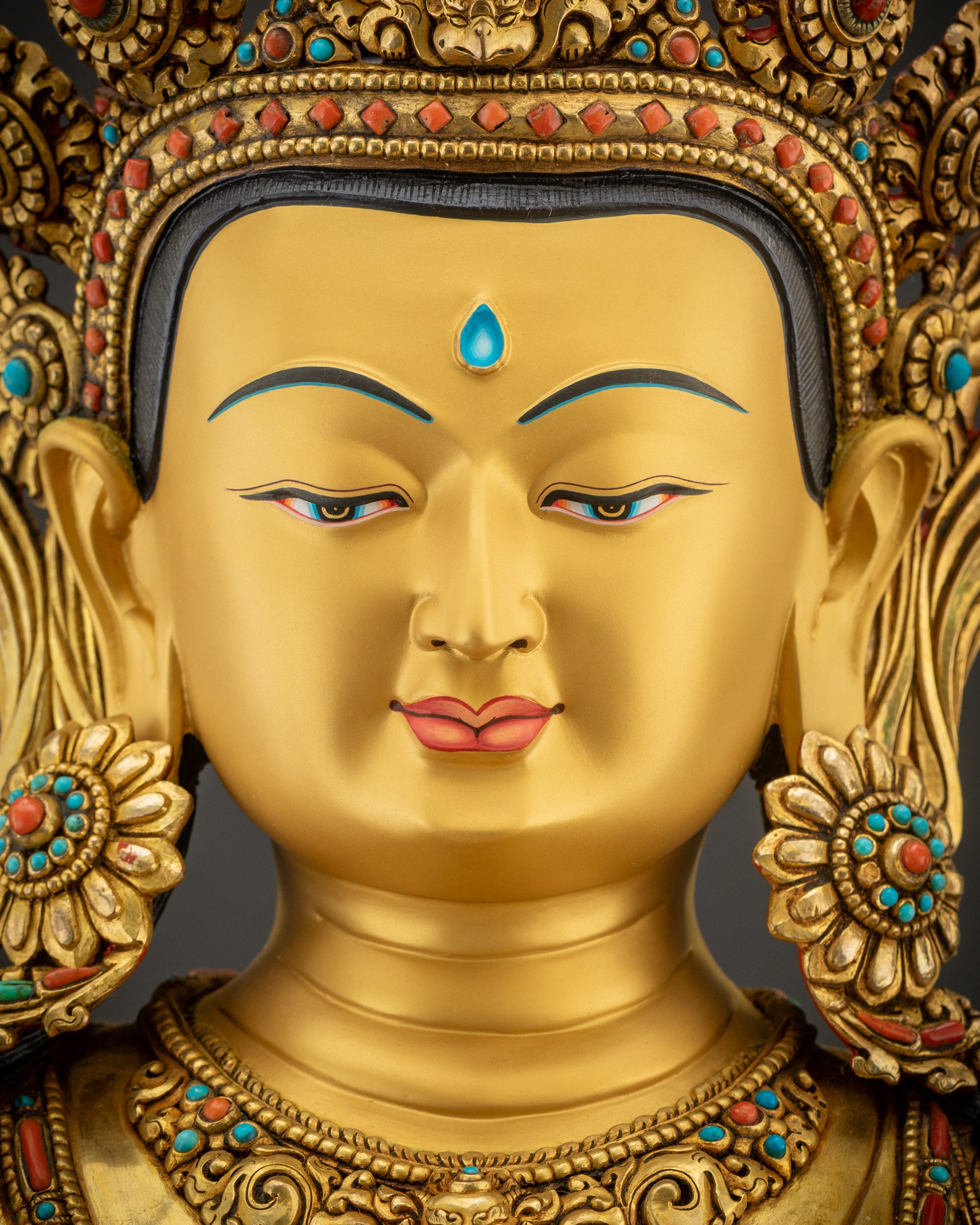 detailed close up of face Manjushri statue gold-gilded serene Buddhist deity

