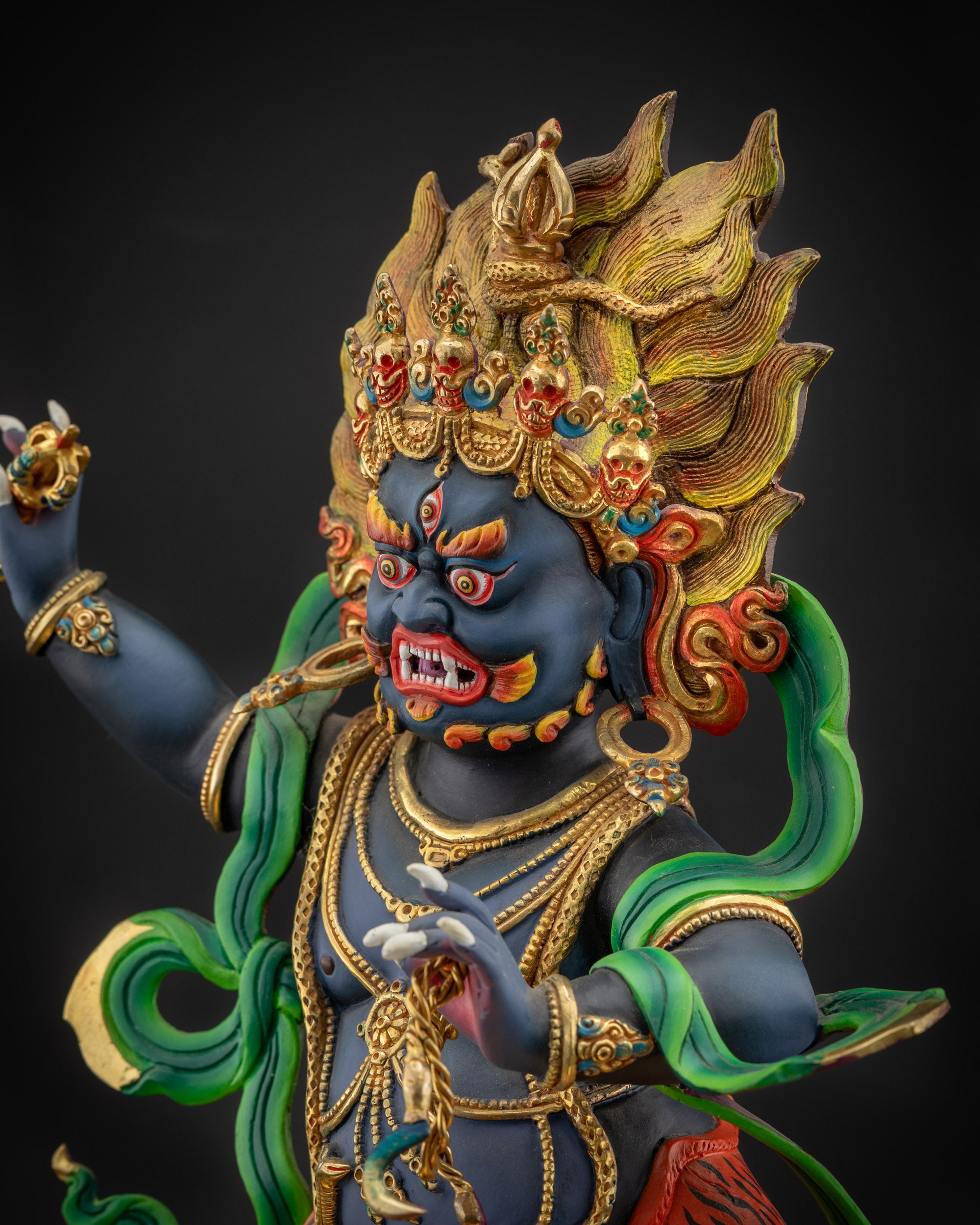 detailed side view Vajrapani statue showing skull crown and ornate earrings
