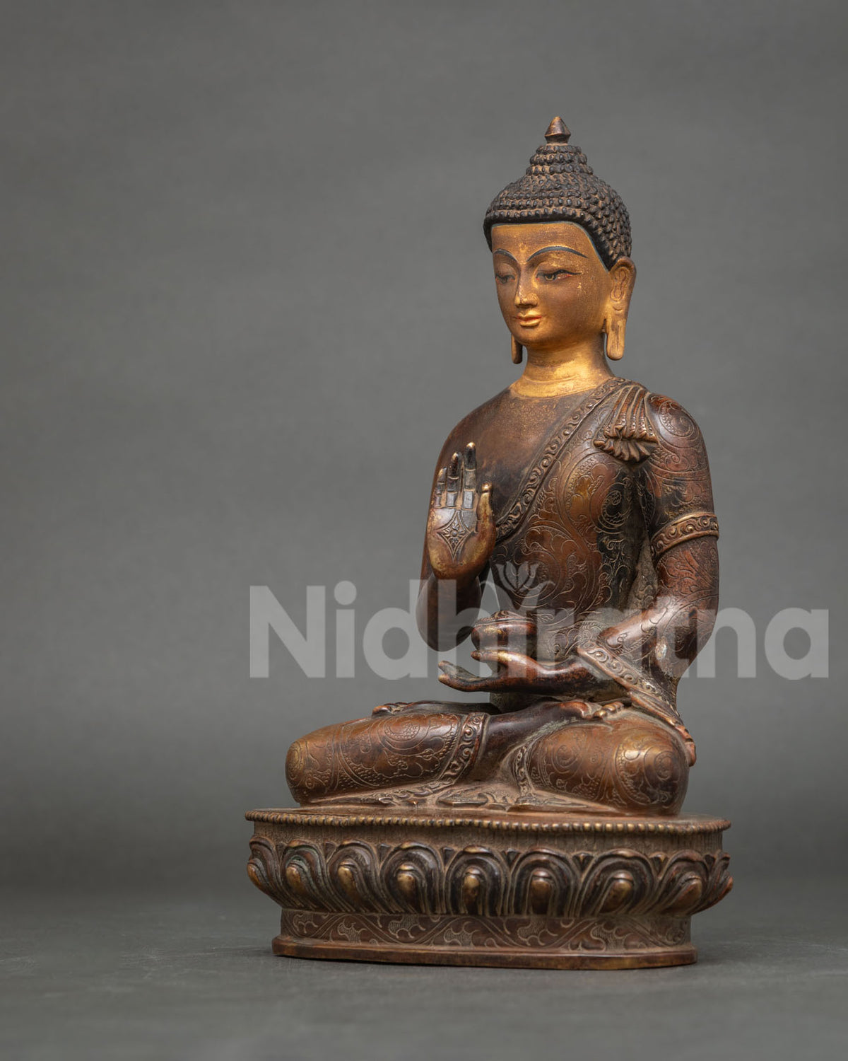Dhyani Buddha Amoghasiddhi statue with hand-carved floral robe details and gold painted face.