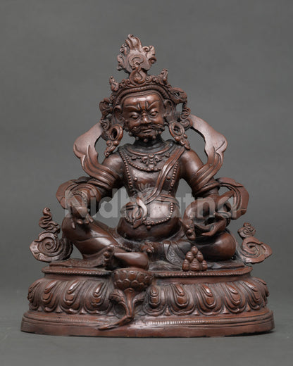 Dzambhala Buddhist wealth deity seated on lotus throne holding a mongoose and citron fruit symbolizing prosperity.
