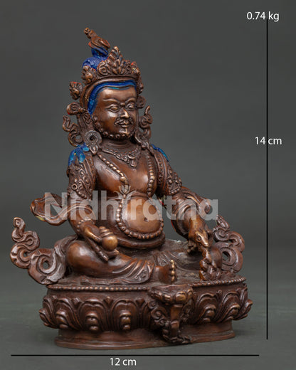Dzambhala sculpture holding a jewel-spouting mongoose and wish-fulfilling jewel symbolizing abundance