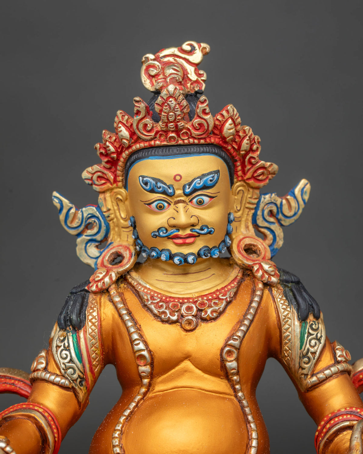 Dzambhala statue 24K gold painted face multicolor double lotus pedestal close up.
