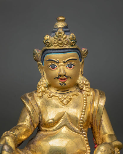 Dzambhala statue 24K gold painted face semi wrathful expression close up.