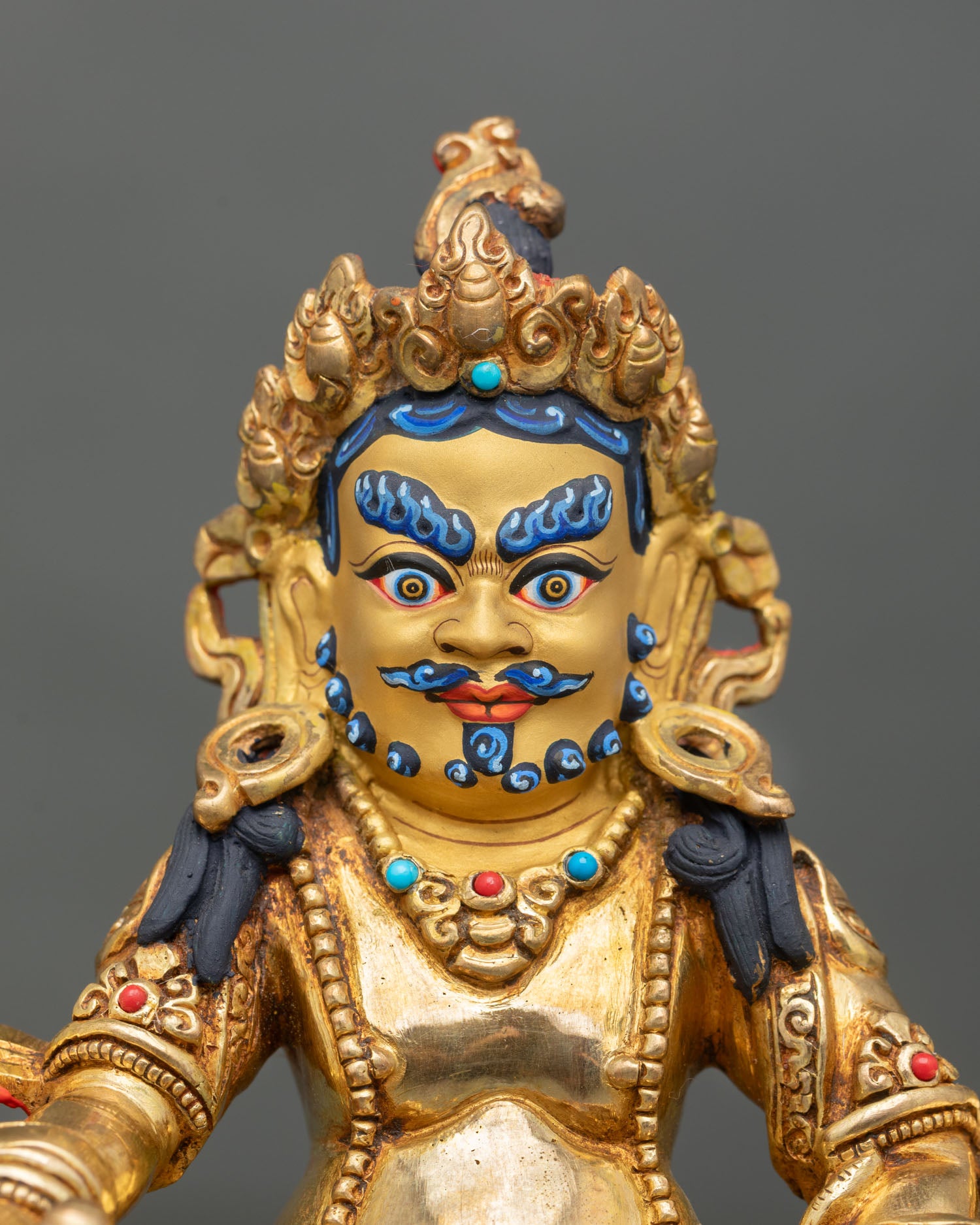Dzambhala statue close up detail five jeweled crown mongoose citron fruit semi precious stones Buddhist prosperity god art