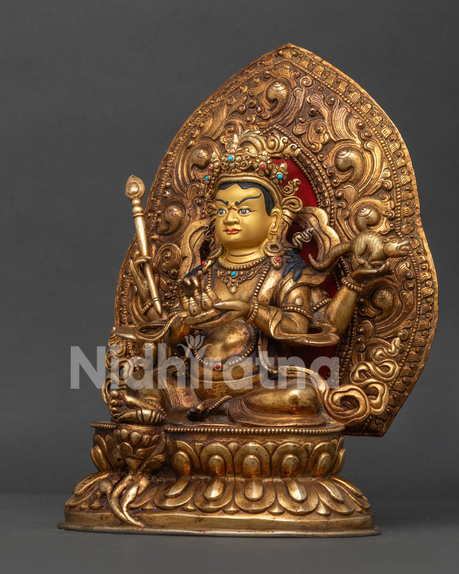 Dzambhala statue detailed side view with floral motif halo and lotus pedestal.
