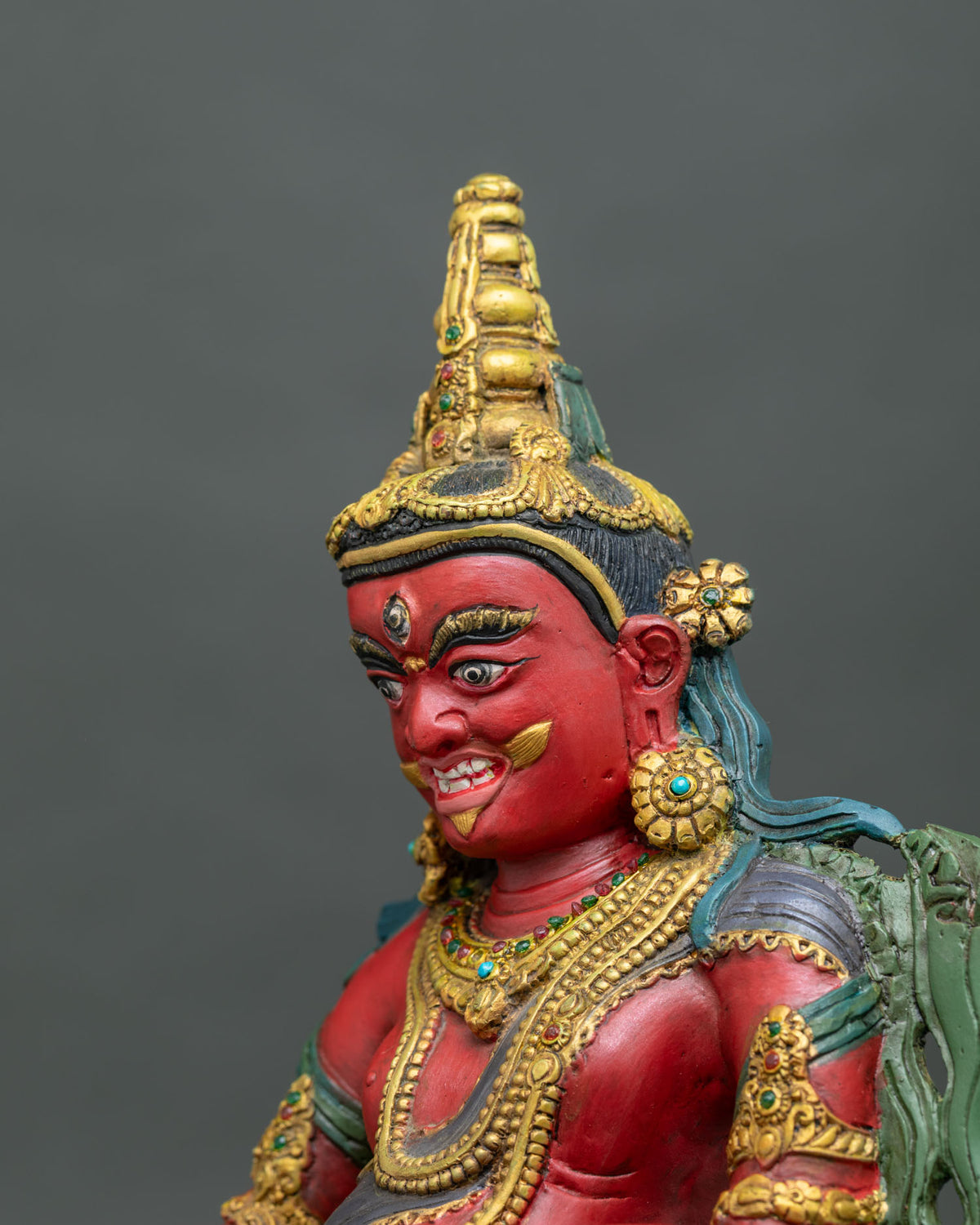 Dzambhala Statue face close up traditional Nepalese Buddhist sculpture.