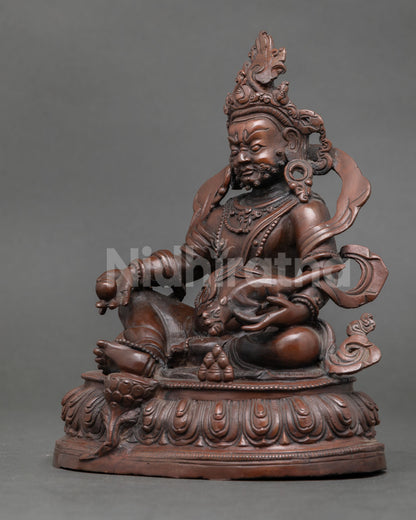 Dzambhala statue handcrafted by Newari artisan from Patan Nepal with oxidized copper finish and lotus pedestal.