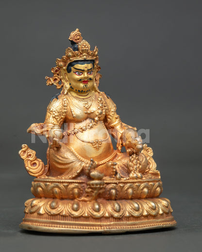 Dzambhala statue holding citron fruits and jewel spitting mongoose.