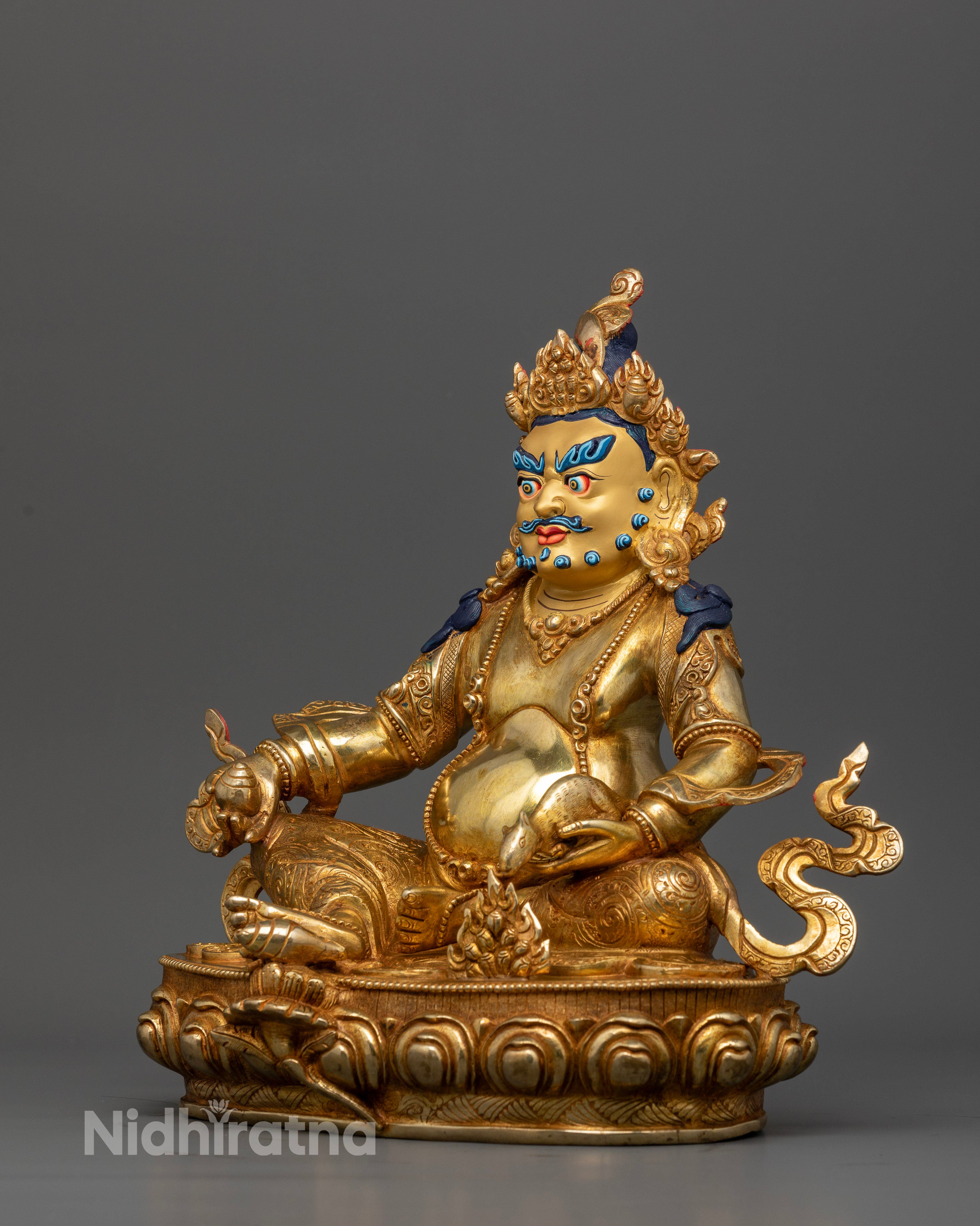 Dzambhala statue holding citrus fruit with jewel spitting mongoose on lotus pedestal.