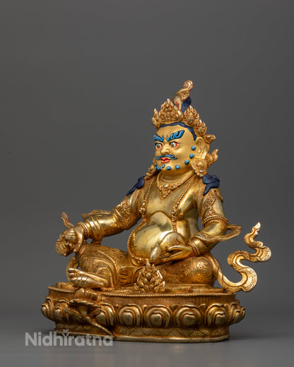 Dzambhala statue holding citrus fruit with jewel spitting mongoose on lotus pedestal.