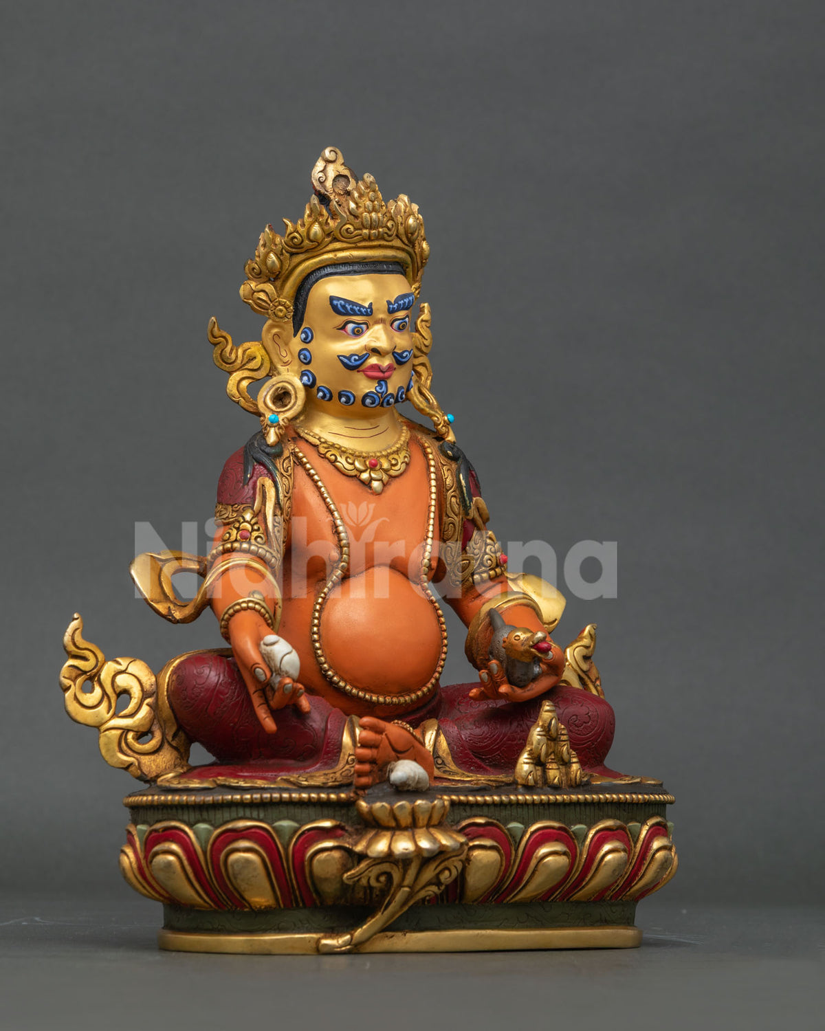 Dzambhala statue seated on detailed lotus throne.